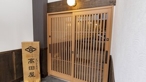 En tremmedør med et skilt med japanske tegn og et logo.
