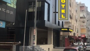 A modern building with a prominent vertical sign for "POZCU HOTEL" on the facade. - Pozcu Otel (Mersin)