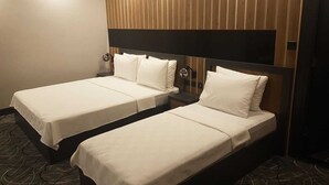 Two single beds with white linens in a room with wooden paneling and a dark headboard. - Pozcu Otel (Mersin)