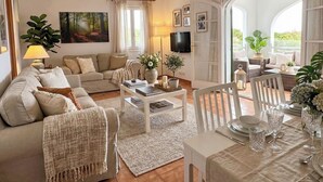 Un salon spacieux comprenant un canapé, une table basse et un coin repas aménagé pour prendre un repas.