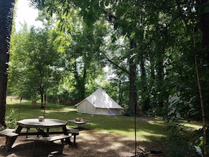 Enjoy a peaceful retreat in our serene outdoor camping area, surrounded by lush greenery and trees.