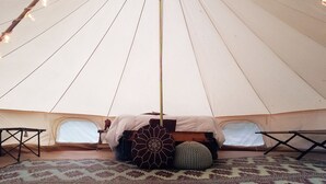 A tent with a bed, pillows, and string lights. - Large Bell Tent on the Kings River! (Eureka Springs)