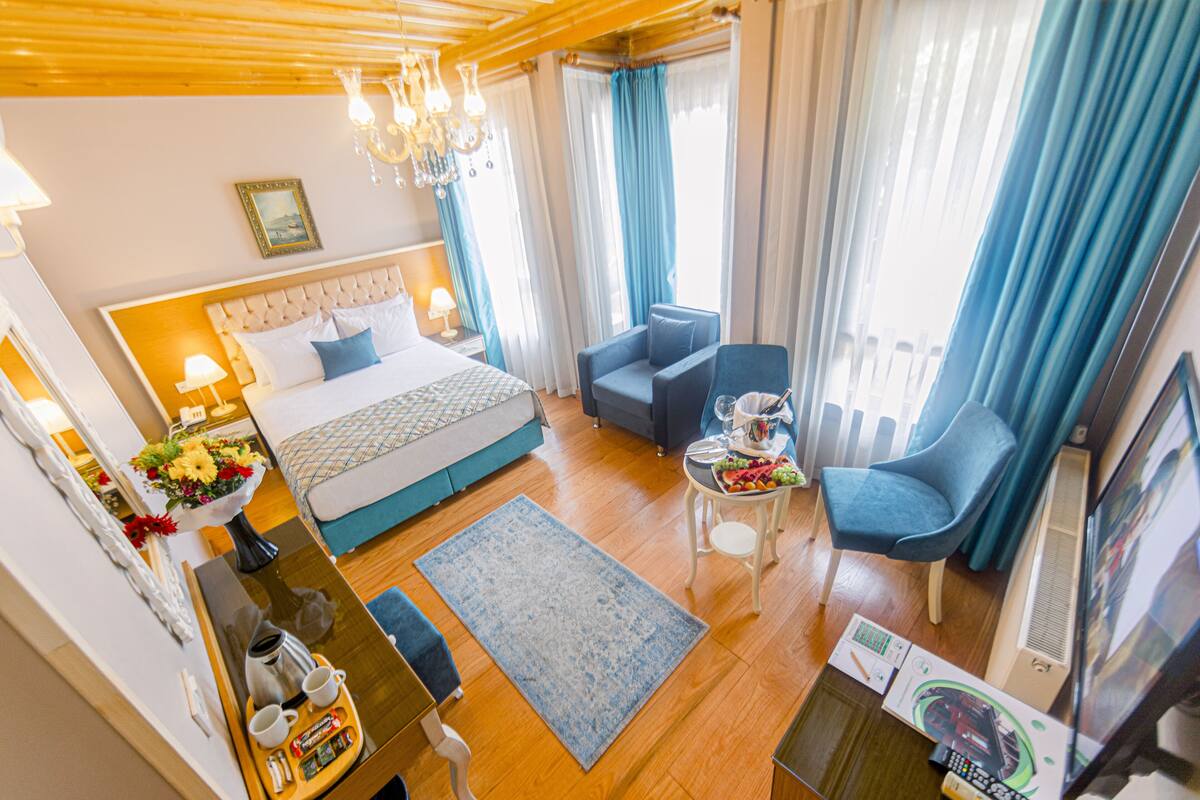 Une chambre d’hôtel avec un lit, un bureau avec un ordinateur, une chaise et un téléviseur.