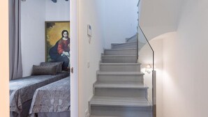 A staircase leading to a bedroom with a bed and a painting on the wall. - Tourist apartment, located in the center of Seville (SEVILLA)