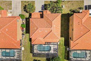 A residential area with multiple houses, each featuring a swimming pool and a tiled roof.
