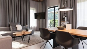 A modern living room with a sofa, coffee table, and dining area.