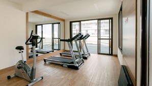 A gym with exercise equipment, large windows, and a wooden floor. - Jacques Pilon Residence (São Paulo)