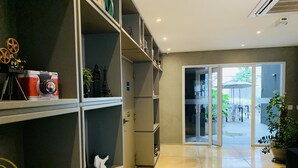 A modern interior with a spacious living area, a sliding glass door leading to an outdoor patio, and a bookshelf with various items.