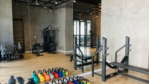 A gym with various exercise equipment, including kettlebells, dumbbells, and weight machines. - Akile Smart Vila Madalena (São Paulo)