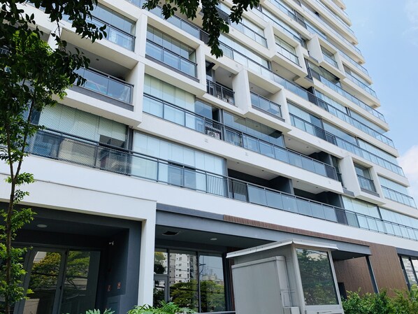 Um edifício de vários andares com design arquitetônico moderno, com varandas e janelas amplas.