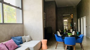 A modern living room with a sofa, chairs, and a dining table. - Akile Smart Vila Madalena (São Paulo)