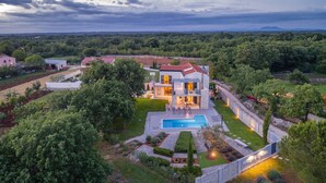 A modern two-story house with a swimming pool, surrounded by landscaped gardens and a view of the countryside. - Villa Lounge Kapelana in Istria, Pool, Garden, BBQ (Svetvinčenat)