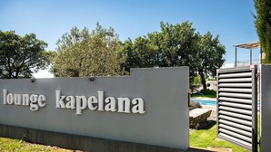 A sign for 'lounge kapelana' with a view of a pool and trees in the background. - Villa Lounge Kapelana in Istria, Pool, Garden, BBQ (Svetvinčenat)