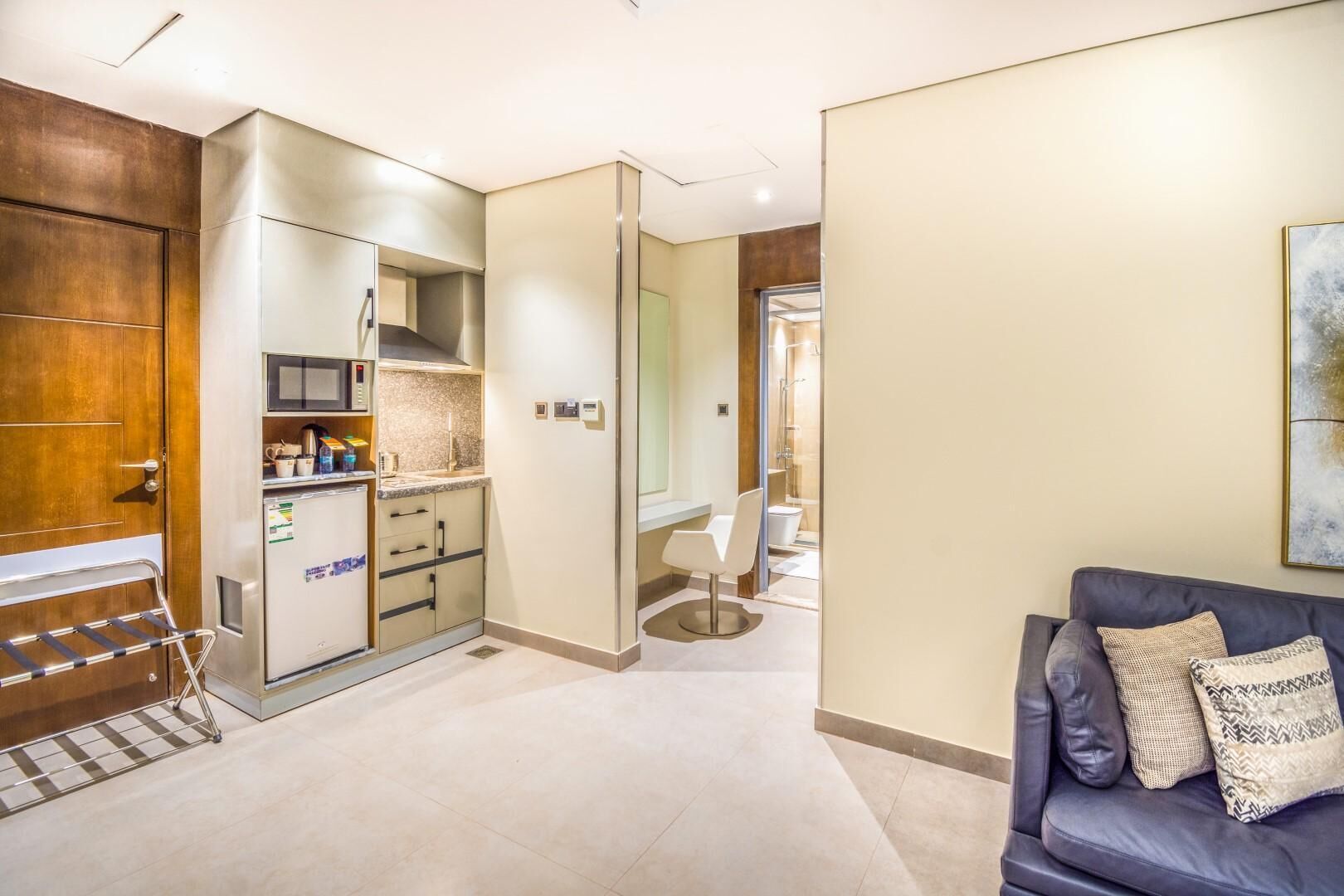 A modern interior with a kitchenette, a seating area, and a shower.