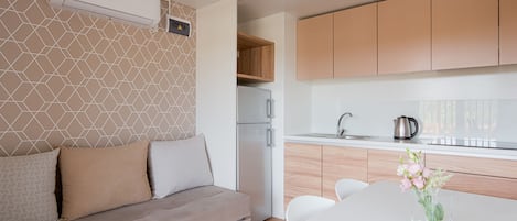 A modern kitchen with a built-in oven, a white refrigerator, and wooden cabinets.