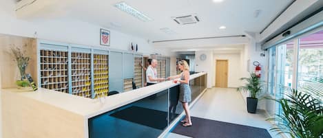 A reception area with a counter, a clock, and a fire extinguisher.