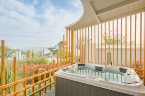 A hot tub on a deck with a view of a body of water and mountains in the background. - Elements Camp Selce (Crikvenica)