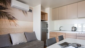 Een moderne keuken met een koelkast, koffiezetapparaat en een eethoek met tafel en stoelen.