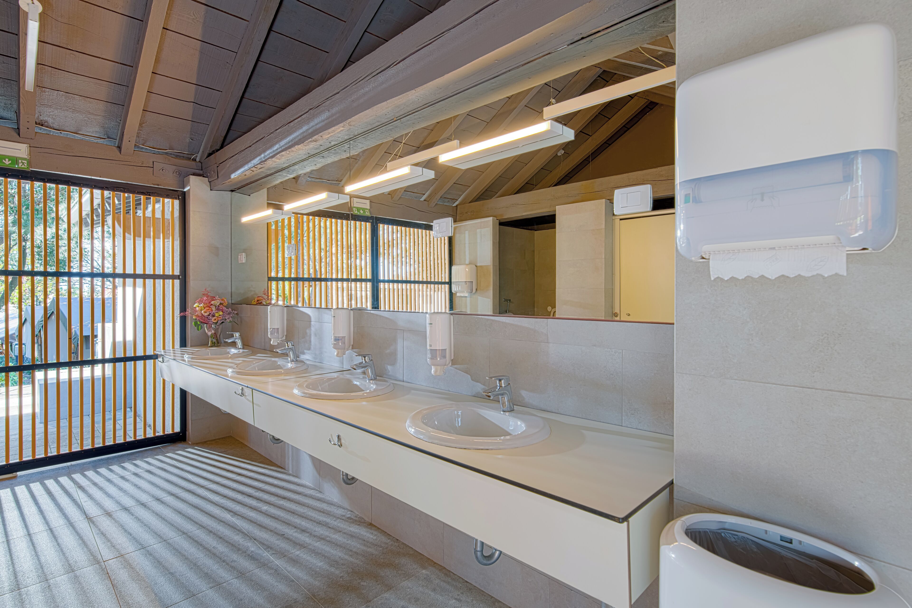 Une salle de bain moderne avec deux lavabos, un grand miroir et des toilettes.