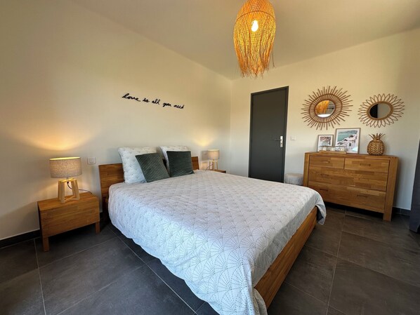 A bedroom with a bed, bedside tables, a dresser, a door, and wall decor. - "Le bellevue", comfortable and peaceful (St Paul de Vence)