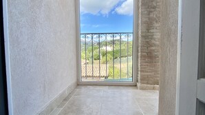 Un balcón con vistas a un paisaje verde y un cielo despejado.