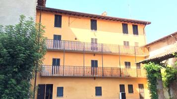 A multi-story building with balconies and a gravel courtyard.