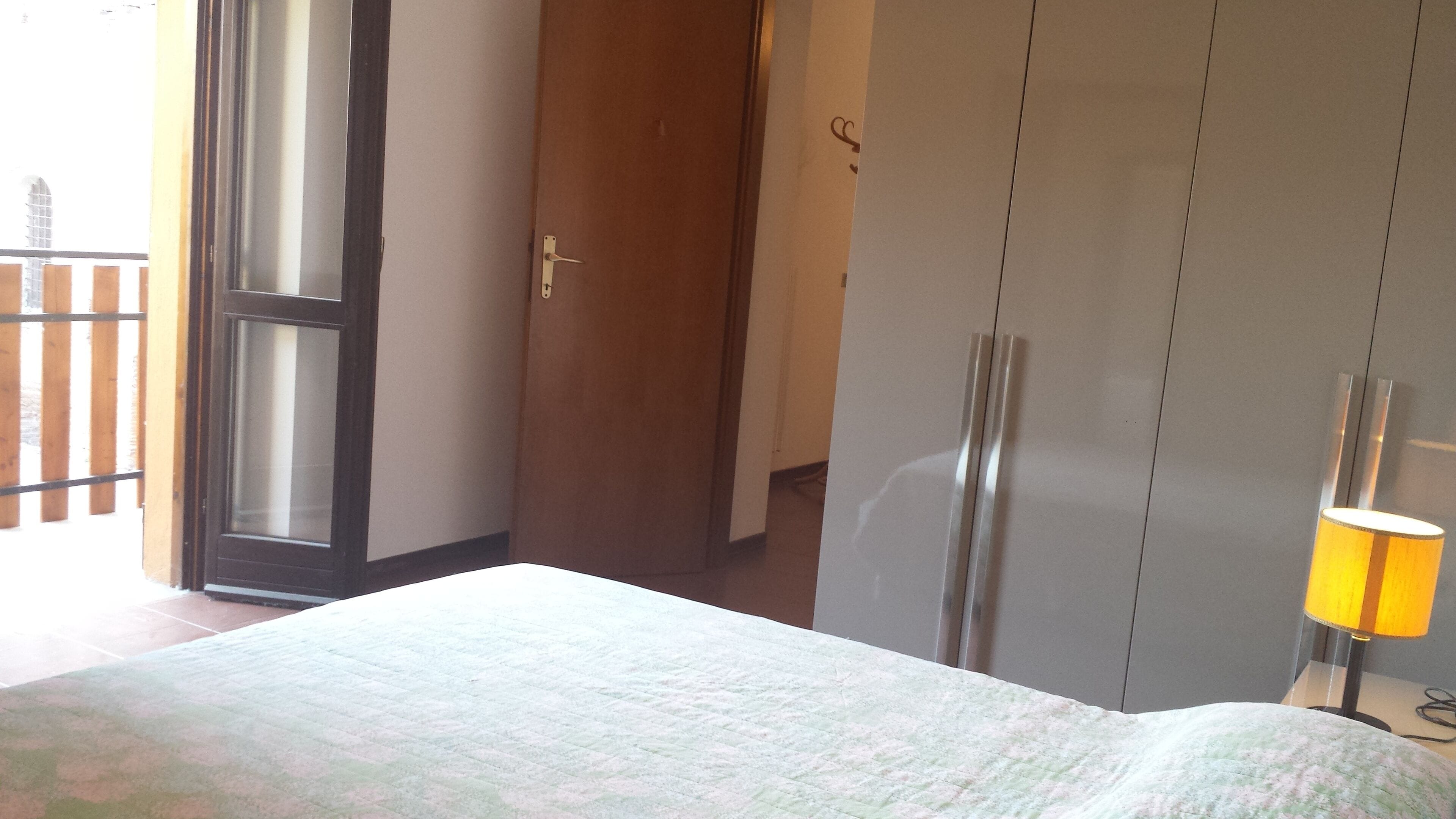 Makuuhuoneessa on sänky, vaatekaappi ja ovi, joka johtaa parvekkeelle.