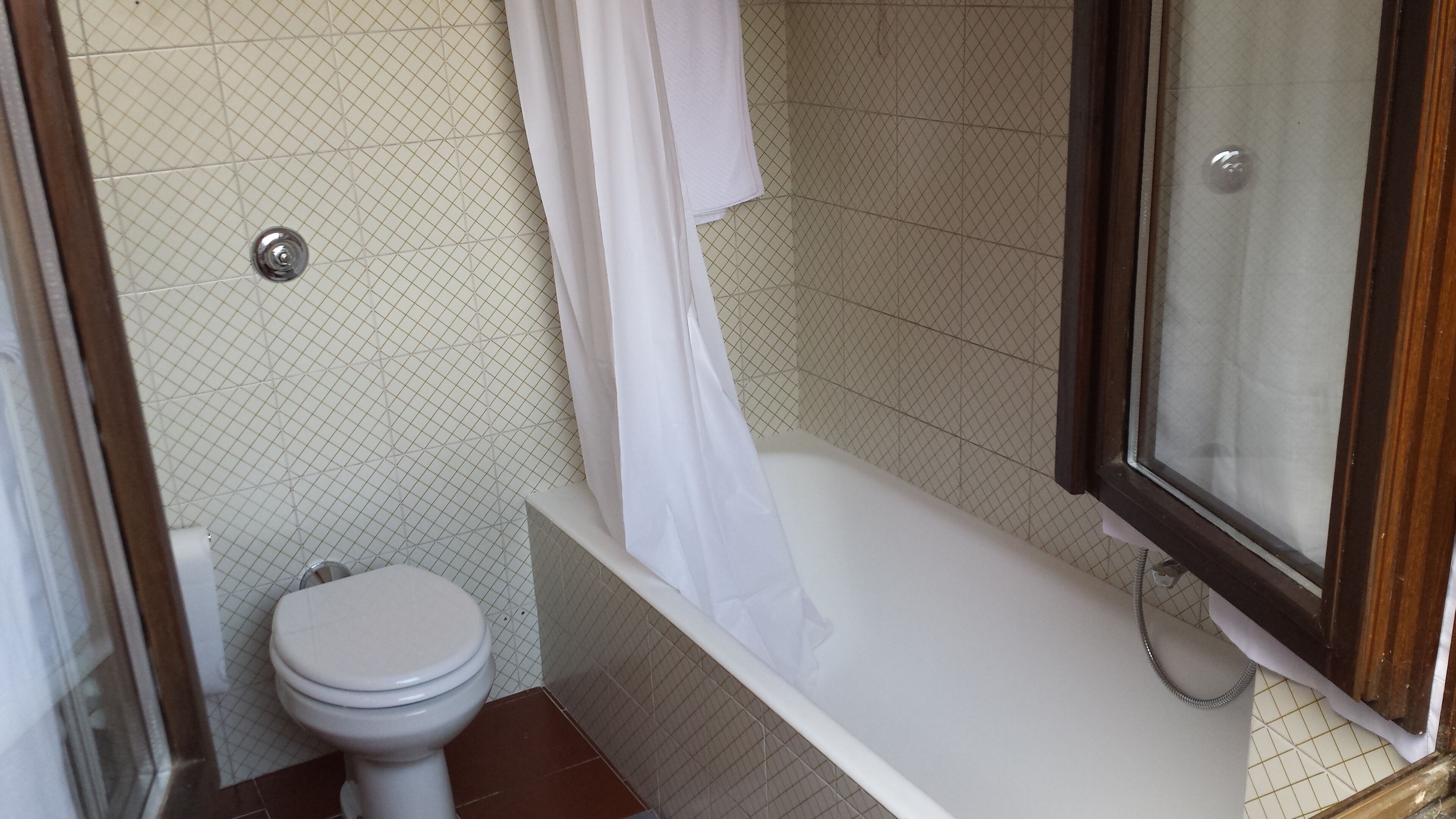 Un baño con inodoro, bañera y zona de ducha.