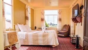 Una habitación de hotel con una cama, una silla, una mesa y un televisor.