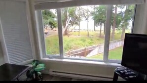 A room with a large window, a radiator, and a small table.