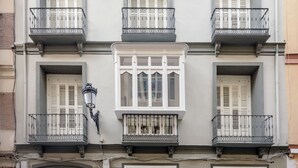 A multi-story building with balconies, large windows, and a door. - Graffiti Suites El Museo (Málaga)