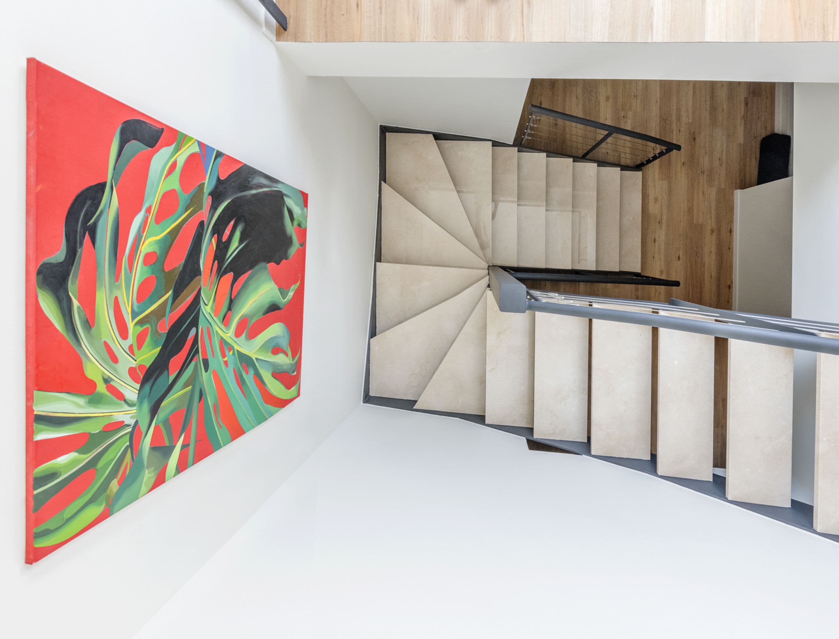 Una escalera moderna con diseño geométrico, acabado de madera y barandilla de metal.