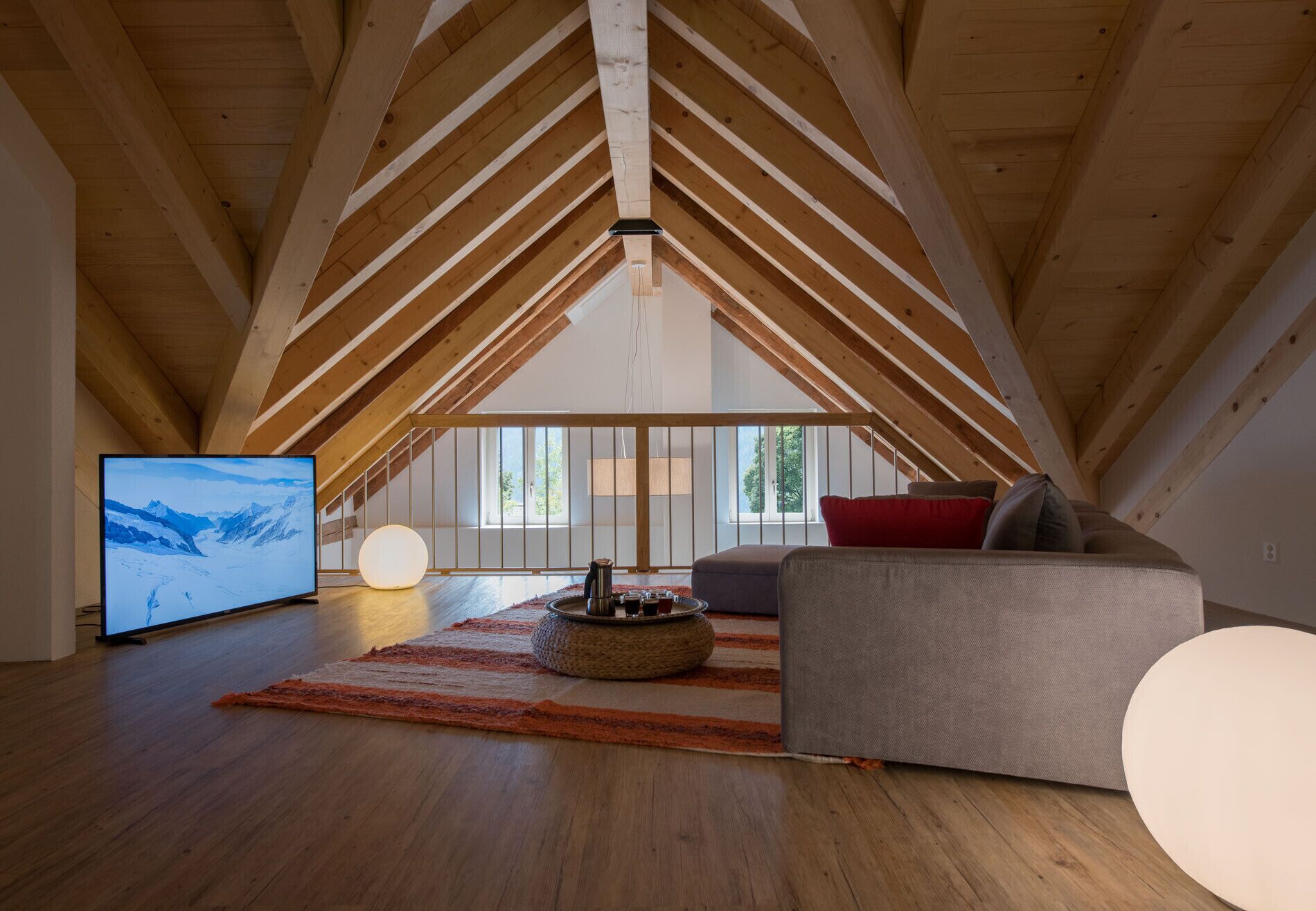 A spacious loft with high ceilings and exposed wooden beams.