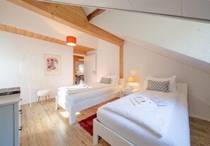 Une chambre moderne avec deux lits, un plafond en bois et un tapis rouge.