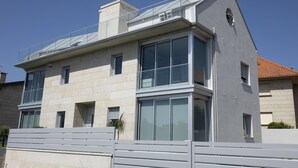 A modern two-story building with large windows and a flat roof. - Two bedroom apartment with garden - DDS ONS (Vigo)