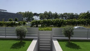 A gated entrance with a modern design, surrounded by well-maintained green lawns and trees. - Two bedroom apartment with garden - DDS ONS (Vigo)