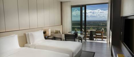 Habitación de hotel con dos camas, televisión, balcón con mesa y sillas, y vista a la ciudad.