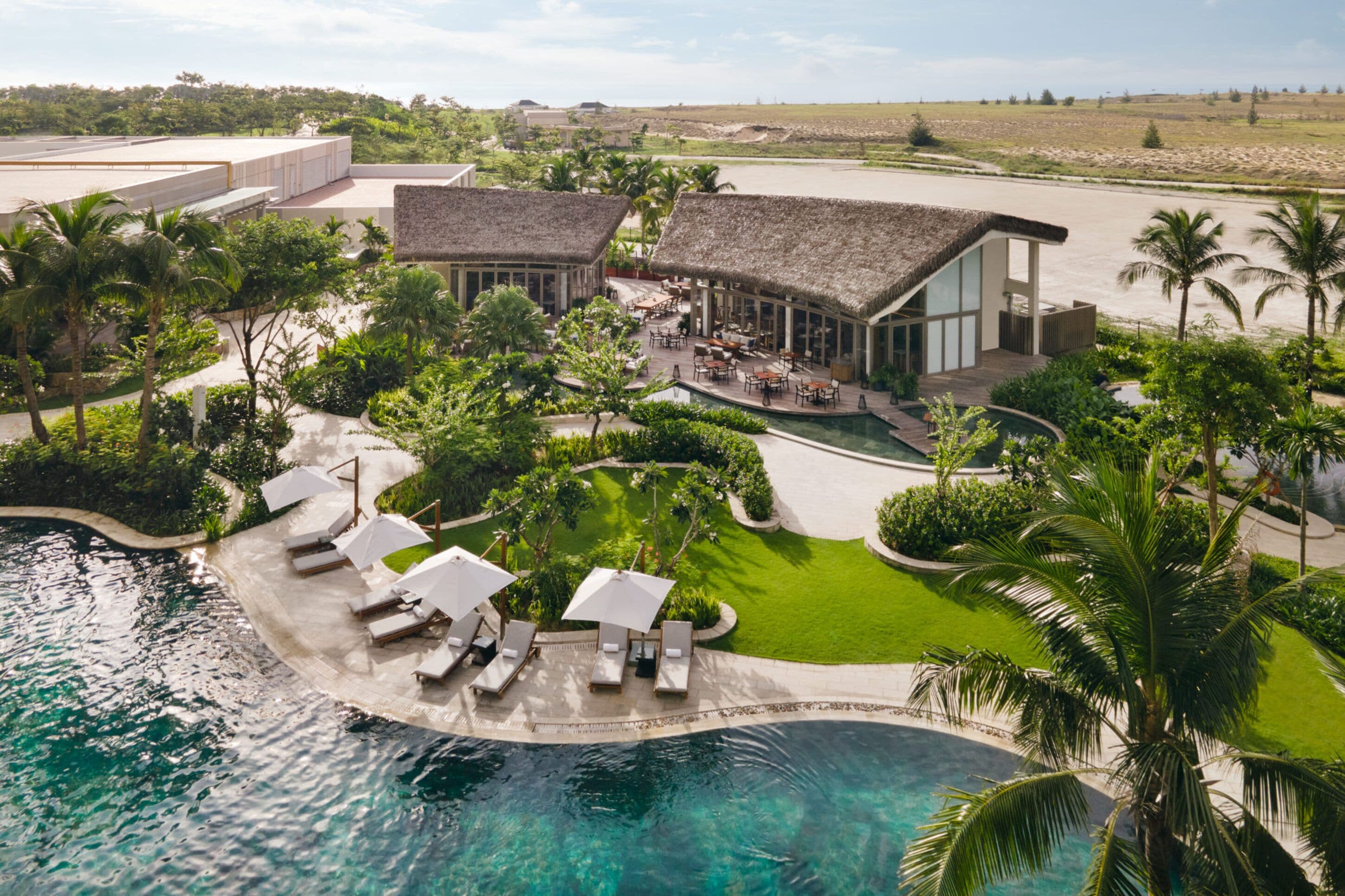 Un complexe hôtelier doté d’une piscine, de chaises longues et d’un restaurant.