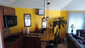 A kitchen with a microwave, a sink, and a dining area with a couch and a plant. - Home AWAY FROM HOME!!! Franklin, VA<br>(1 BEDROOM) (Franklin)