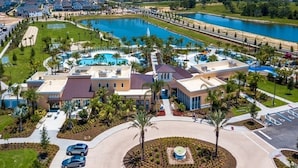 An aerial view of a resort with a swimming pool, a golf course, and a marina.