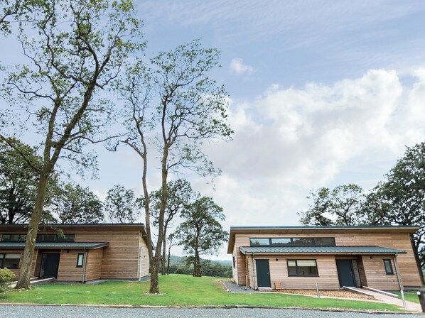 Un bâtiment moderne à deux étages, doté d’un toit plat, de grandes fenêtres et d’une pelouse bien entretenue.
