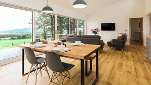 Un espacio moderno de estar con comedor, sofás y televisión.