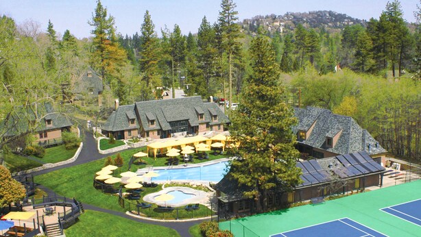 A resort with multiple buildings, a swimming pool, tennis courts, and a forested backdrop. - UCLA Lake Arrowhead Lodge (Lake Arrowhead)