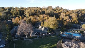 An aerial view of a resort with a swimming pool, lounge chairs, and a well-maintained lawn. - UCLA Lake Arrowhead Lodge (Lake Arrowhead)