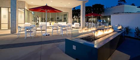 Una piscina al aire libre, sombrillas, sillones reclinables de piscina