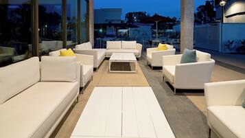 An outdoor seating area with white sofas and a central coffee table.
