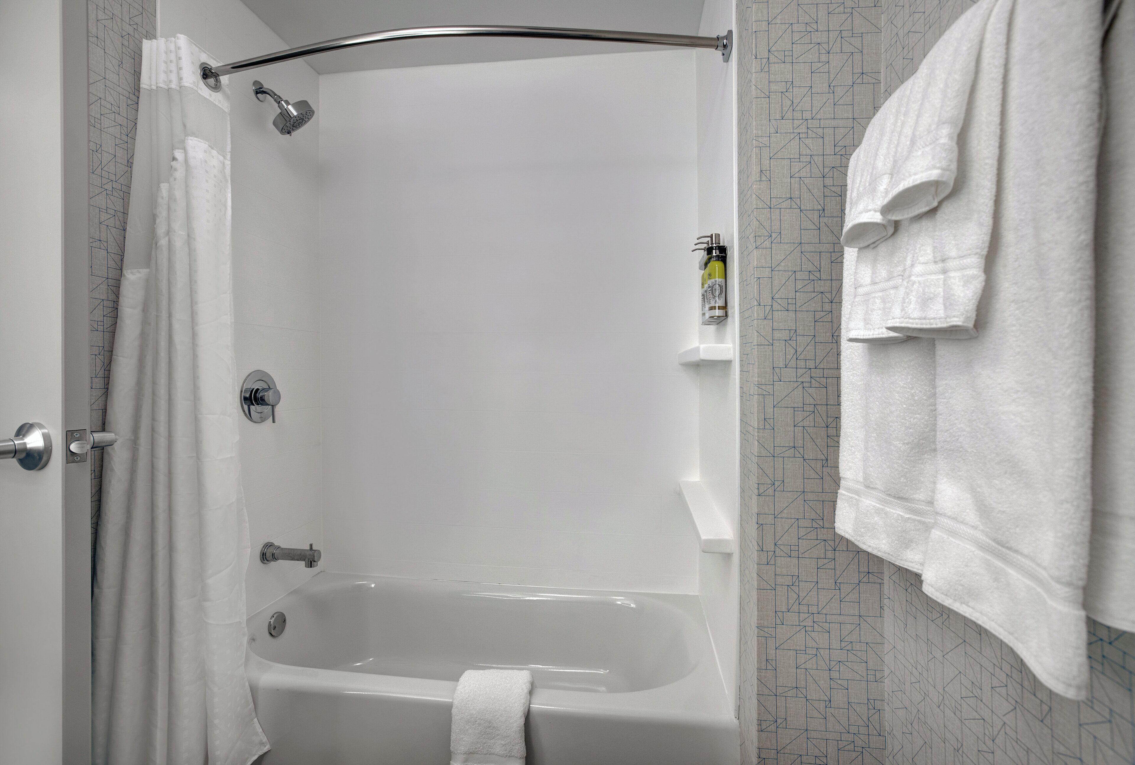 Un baño moderno con bañera, ducha y perchero.