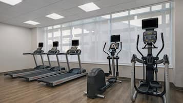 A gym with treadmills, elliptical machines, and a stationary bike.