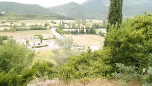 Un paysage rural avec une route, des bâtiments et de la végétation.