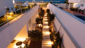 A rooftop terrace with a pathway, seating, and potted plants. - Santa Caterina - Dimora sul mare (Polignano a Mare)